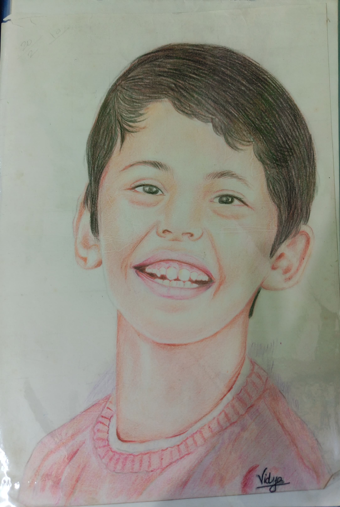 Colour-pencil portrait of a smiling boy, by Vidya Kathare